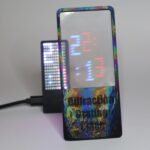 A close-up view of Moritz Von Sivers' diffraction grating clock, showing blue hours and red minutes separated by light refraction on an LED display.
