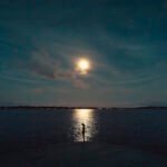 A luminous full moon shining brightly in a night sky, symbolizing culmination and new beginnings, with a subtle hint of the Capricorn seagoat.