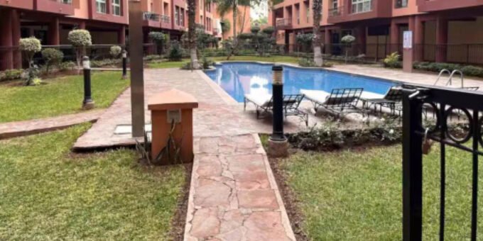 Vue aérienne d'une villa de luxe avec piscine et jardins luxuriants à Marrakech, sous un ciel bleu, symbolisant l'essor du marché immobilier premium de la ville.