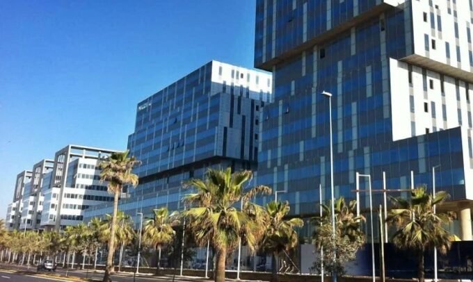Vue aérienne d'un parc logistique moderne au Maroc, avec des entrepôts et des camions, symbolisant les nouvelles opportunités d'investissement.