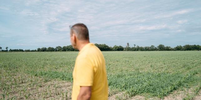 Des agriculteurs manifestent près d'un champ irrigué, symbolisant la tension autour de la gestion de l'eau.
