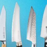 A selection of high-quality mid-sized kitchen knives, including Messermeister and Zwilling models, arranged on a wooden cutting board.