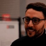 Mobilité étudiante vers la France : les clés d'un projet réussi 8 Un étudiant marocain souriant devant un monument parisien, symbolisant la réussite de ses études en France.