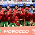 Mondial 2026 : Les Lions de l'Atlas à l'école des nouvelles règles FIFA pour déjouer les pièges 4 L'équipe nationale marocaine, les Lions de l'Atlas, en pleine discussion avec leur staff technique sur un terrain de football, symbolisant la préparation aux nouvelles règles de la FIFA pour la Coupe du Monde 2026.