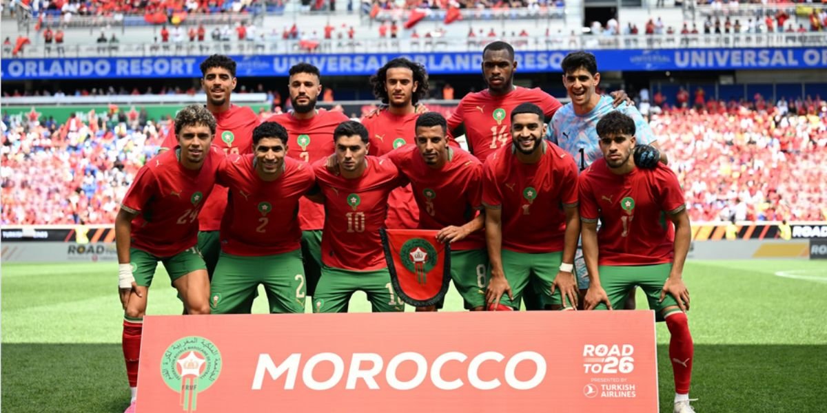Mondial 2026 : Les Lions de l'Atlas à l'école des nouvelles règles FIFA pour déjouer les pièges 3 L'équipe nationale marocaine, les Lions de l'Atlas, en pleine discussion avec leur staff technique sur un terrain de football, symbolisant la préparation aux nouvelles règles de la FIFA pour la Coupe du Monde 2026.