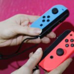 Close-up of a Nintendo Switch Joy-Con controller, highlighting the analog stick, symbolizing the 'stick drift' problem.