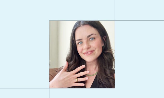 An Oura Ring 4 in gold on a finger, illustrating its sleek design and wearability.