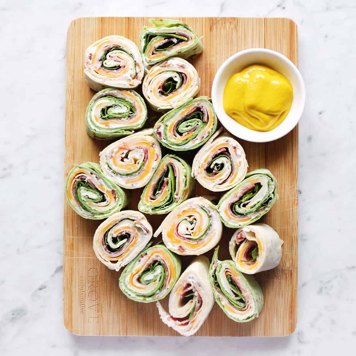 A vibrant platter of colorful pinwheel sandwiches, neatly sliced and arranged, ready to be served.