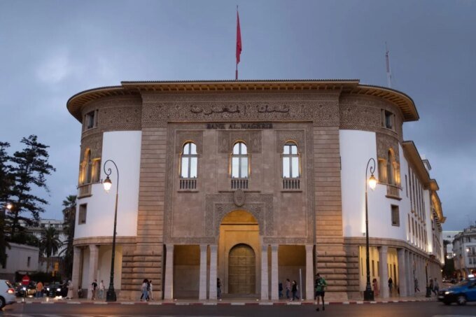 Logo Revolut et bâtiment de Bank Al-Maghrib, symbolisant la confrontation entre la fintech et le régulateur marocain.