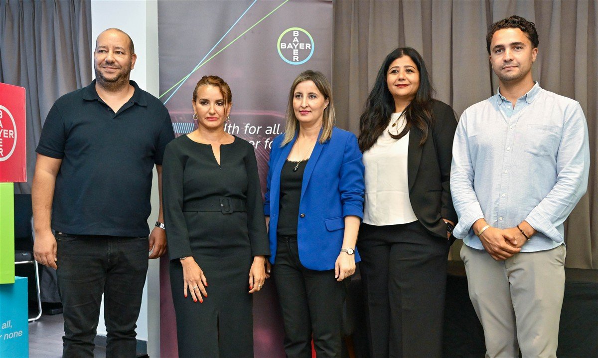 Des experts de Bayer Maroc présentant des solutions agricoles durables dans un champ de céréales luxuriant de la région du Gharb.
