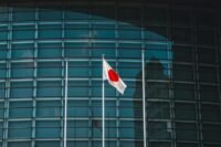 Ripple RLUSD stablecoin logo against a backdrop of Japanese financial buildings, symbolizing regulatory approval and market entry.