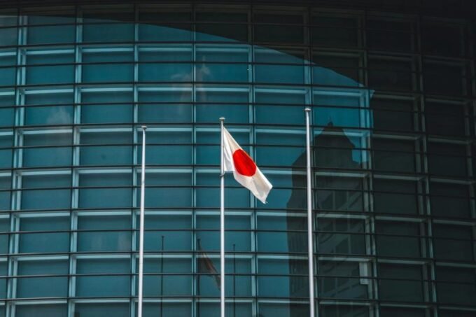 Ripple RLUSD stablecoin logo against a backdrop of Japanese financial buildings, symbolizing regulatory approval and market entry.