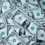 Digital dollar symbols flowing into traditional financial assets, representing stablecoins becoming productive capital.
