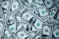 Digital dollar symbols flowing into traditional financial assets, representing stablecoins becoming productive capital.