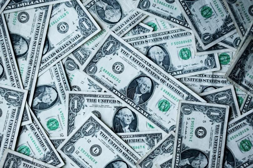 Digital dollar symbols flowing into traditional financial assets, representing stablecoins becoming productive capital.