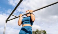 A person lifting weights, symbolizing strength and health, with a blurred background.