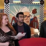 Taskmaster contestants Joel Dommett and Kumail Nanjiani in a cowboy costume, ready for a pillow fight.
