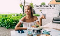 Woman holding a passport and healthy snacks, ready for travel, symbolizing good digestion on the go.