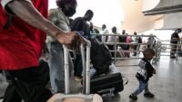 Des migrants sans papiers font la queue dans le hall des départs de l'aéroport international de Tunis-Carthage avant leur rapatriement vers leur pays d'origine.