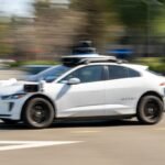 A Waymo autonomous vehicle driving on a street in San Francisco, symbolizing the intersection of technology and urban life.