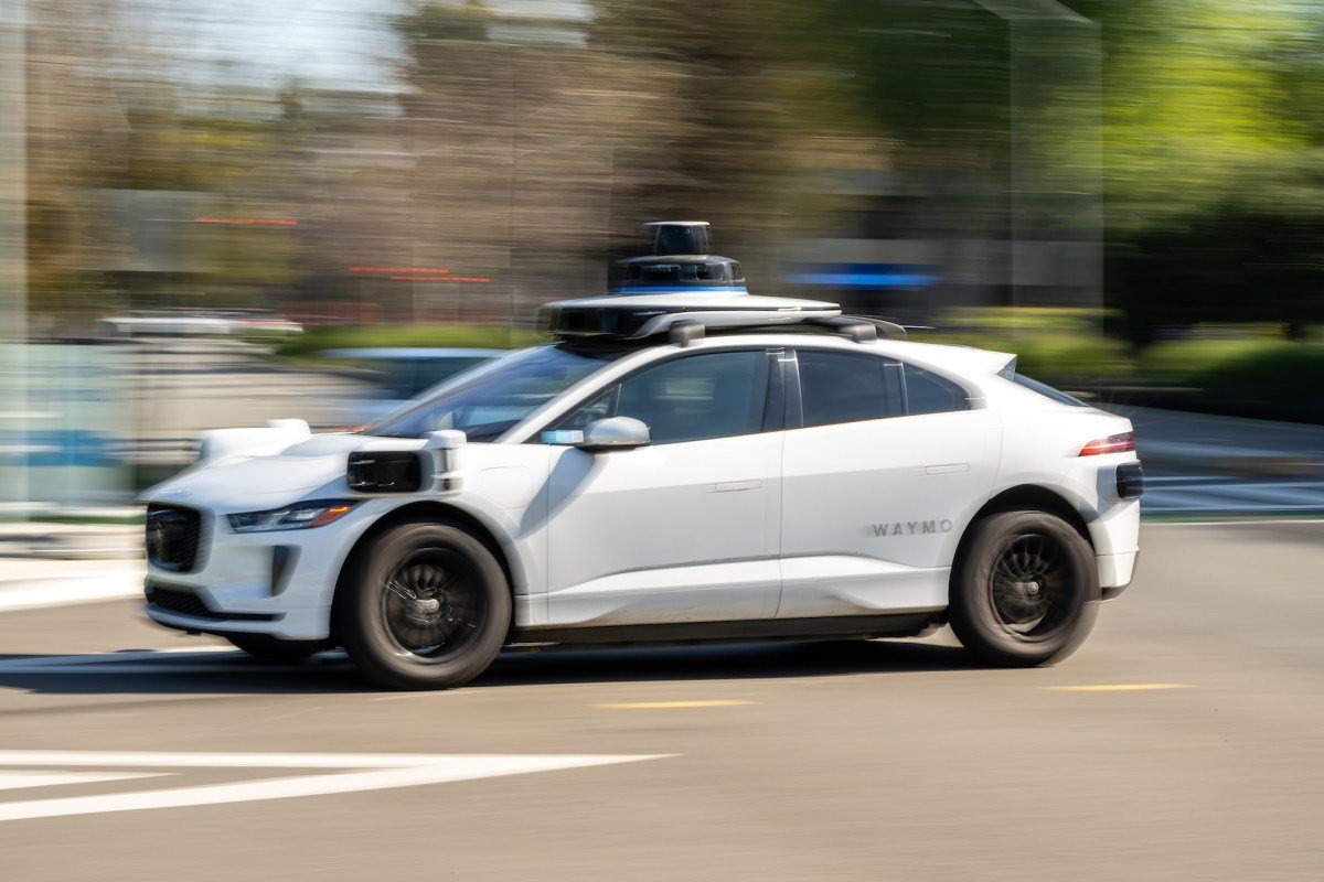 A Waymo autonomous vehicle driving on a street in San Francisco, symbolizing the intersection of technology and urban life.