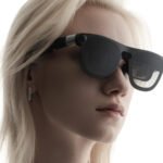 Xreal Aura : L'Aube de la Réalité Étendue en Précommande Limitée, Le Mystère du Prix Demeure 8 Une paire de lunettes Xreal Aura, au design futuriste et épuré, posée sur une surface sombre, avec un reflet subtil sur les lentilles, symbolisant l'immersion dans la réalité étendue.
