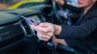 Illustration of a compromised driver's license with digital lock icon, symbolizing data breach and identity theft risk.