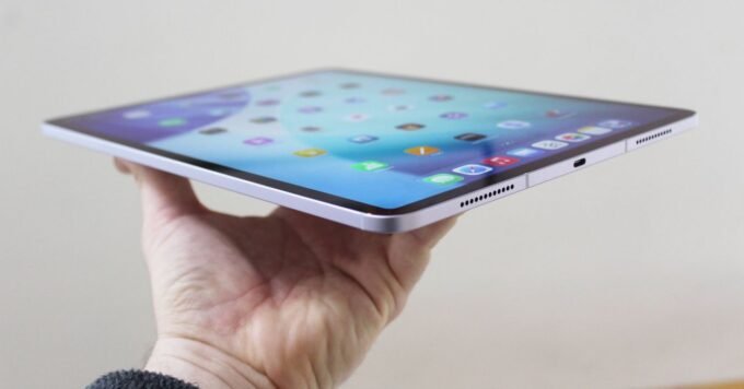 A selection of Apple iPad models, including iPad Air, iPad Pro, and iPad Mini, on a modern desk.