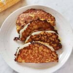 Savoring Venezuela: The Authentic Cachapas Recipe 6 Freshly cooked Venezuelan Cachapas, golden corn pancakes folded over melted white cheese, on a rustic plate.
