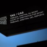 Logo du Tribunal Arbitral du Sport (TAS) avec un ballon de football et les drapeaux du Sénégal et du Maroc en arrière-plan, symbolisant le litige de la CAN 2025.