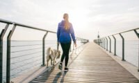 An older adult enjoying a brisk walk outdoors, symbolizing active aging and cognitive health.