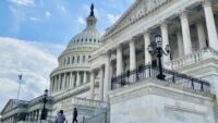 A gavel rests on a desk in front of a blurred image of the U.S. Capitol building, symbolizing legislative action and the delay of the Crypto Clarity Act.