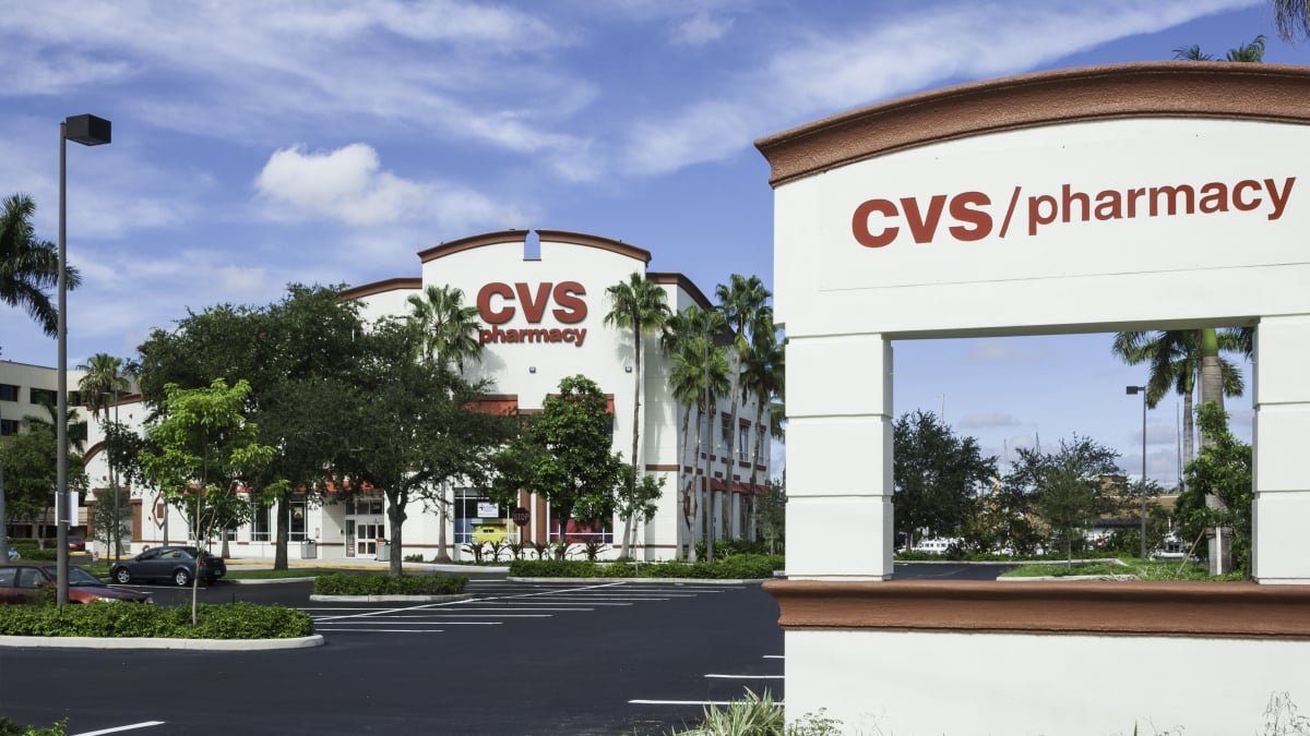 A display of various school supplies like notebooks, pens, and binders with a CVS logo in the background, highlighting back-to-school deals.