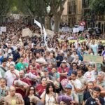 متظاهرون يحملون لافتات في ساحة إسبانيا ببالما، مايوركا، خلال احتجاجات ضد السياحة المفرطة.