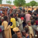 نساء وأطفال ينتظرون للحصول على المساعدات الغذائية في مخيم المهيرة للنازحين بالقرب من الأبيض، جنوب كردفان.