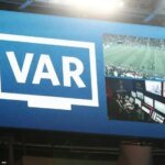صورة لتقنية الفار في ملعب كرة قدم مع شعار مونديال 2026