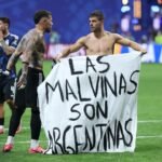 لاعبو كرة القدم الأرجنتينيون نيكولاس أوتامندي وجيوفاني لو سيلسو يحملان لافتة كتب عليها 'المالفيناس أرجنتينية' بعد فوزهم على إنجلترا في كأس العالم 2026.