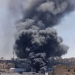 صورة تظهر أعمدة دخان أسود كثيفة وألسنة لهب تتصاعد من مبنى سكني وتجاري في منطقة القويسمة بعمان، مع تواجد لفرق الدفاع المدني.