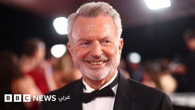 سام نيل: وداع أيقونة "جوراسيك بارك" الذي أثرى السينما العالمية بتنوعه 1 صورة للممثل سام نيل في حفل جوائز، يبتسم وهو ينظر إلى الجمهور.