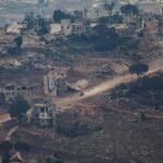 مركبة تمر بجوار مبنى يرفع العلم الإسرائيلي في جنوب لبنان، تعكس التوتر الحدودي.