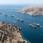 تصعيد خطير في مضيق هرمز: واشنطن تتهم طهران باستهداف سفن تجارية 6 صورة لمضيق هرمز تظهر سفناً تجارية وسفن حربية في الخلفية، تعكس التوترات الأمنية في الممر المائي.