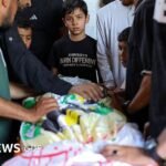 صورة تظهر فلسطينيين يشاركون في مراسم تشييع جثمان ضحية غارة إسرائيلية في مخيم النصيرات، غزة.