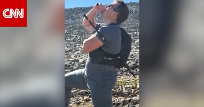 صورة لرجل متسلق في جبال وعرة، ربما يظهر عصا مشي أو إصابة بسيطة.