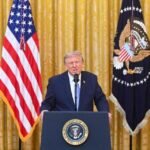 Donald Trump prononçant un discours, avec un drapeau américain en arrière-plan, évoquant la vulnérabilité du système électoral et l'ingérence chinoise.