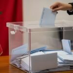 Des militants collant des affiches électorales sur un mur, symbolisant l'engagement désintéressé à la base d'un parti politique.