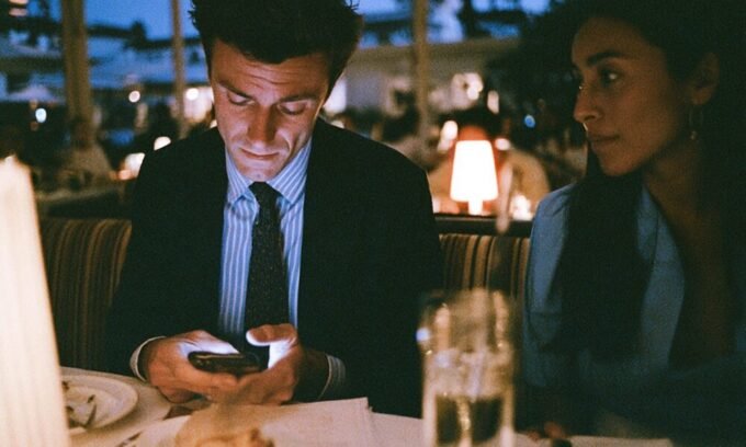 An entrepreneur looking stressed while on a date, with business thoughts on their mind, symbolizing the struggle between startup life and personal relationships.