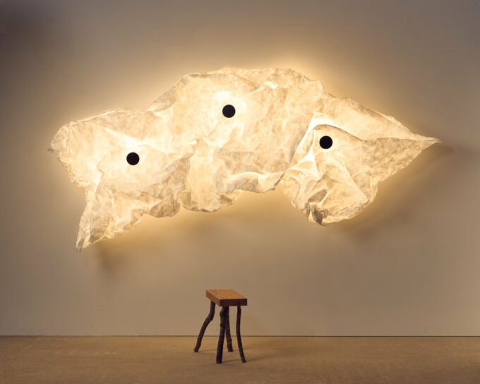 Erwan Bouroullec's Maap: A Revolutionary Wall Lamp Designed for Personal Expression 12 Erwan Bouroullec's Maap wall lamp, showcasing a crumpled Tyvek diffuser secured by magnetic dots on a steel framework, casting a soft, ambient glow on a wall.