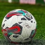 Joueurs de football sur un terrain, symbolisant les matchs de barrage au Maroc.