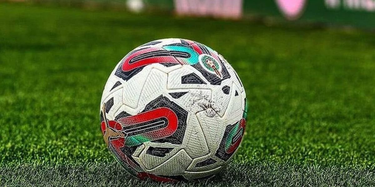 Joueurs de football sur un terrain, symbolisant les matchs de barrage au Maroc.