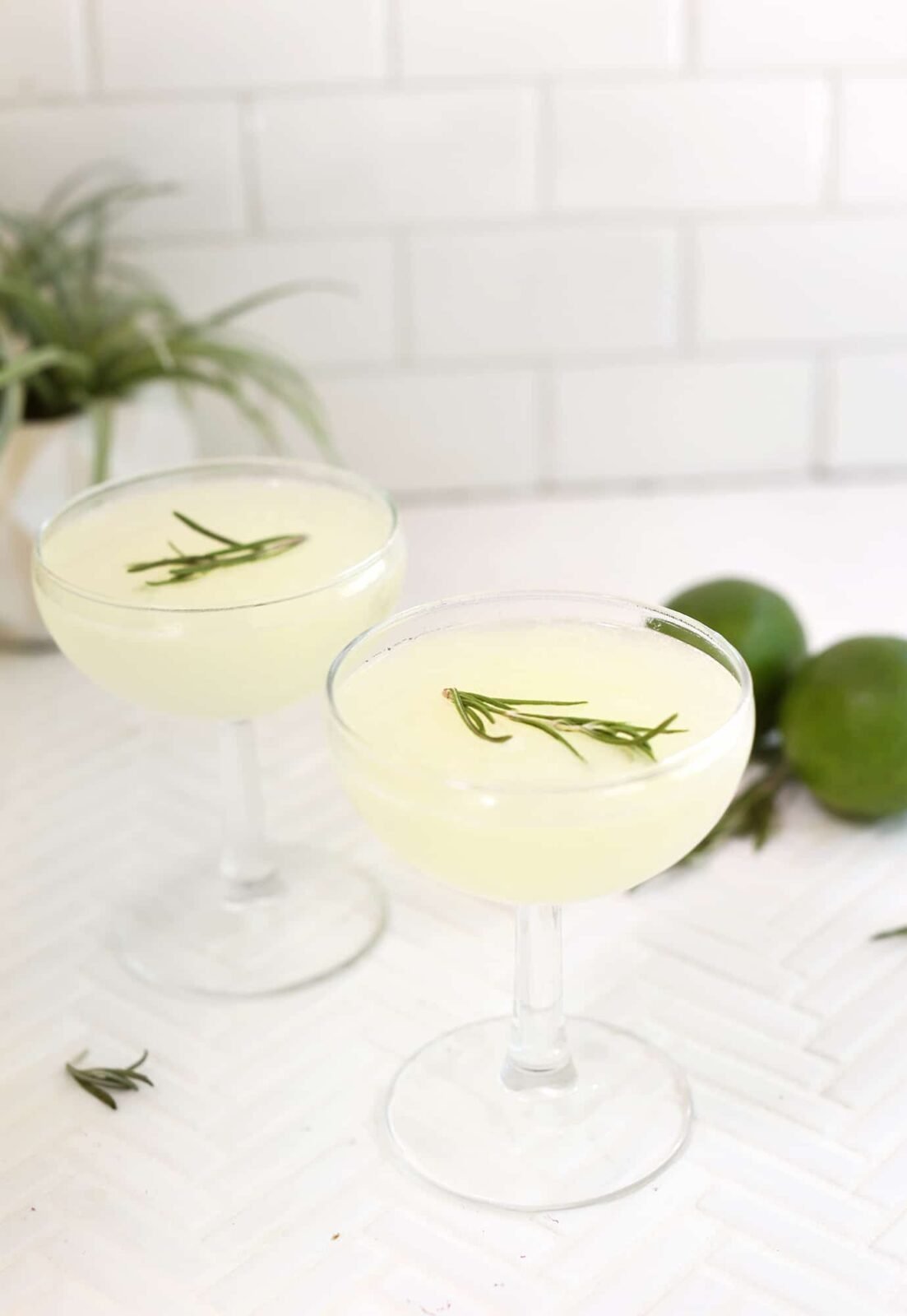 A perfectly chilled Classic Gimlet cocktail in a coupe glass, garnished with a lime wedge.